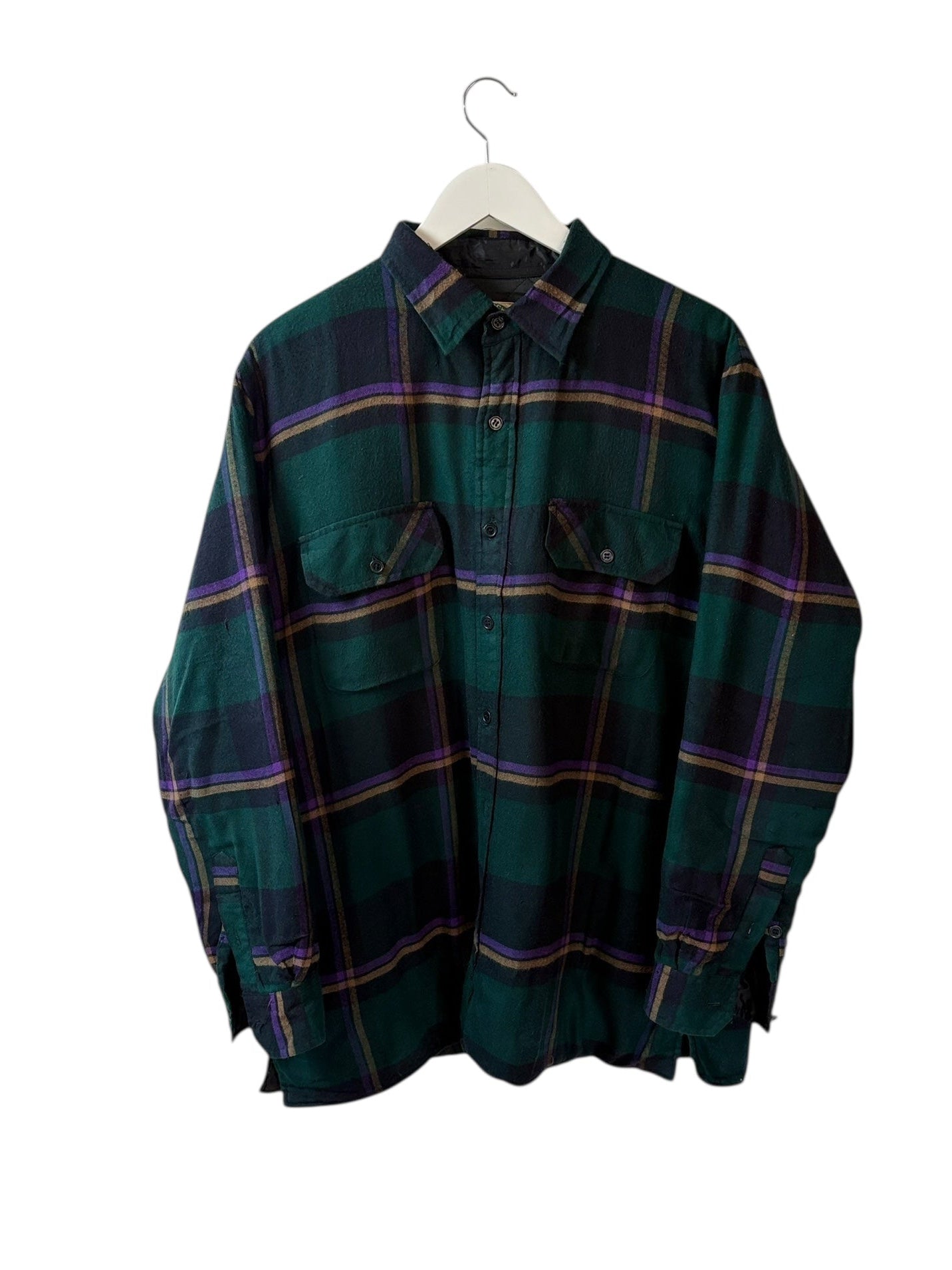 Green plaid shirt on a hanger against a white background