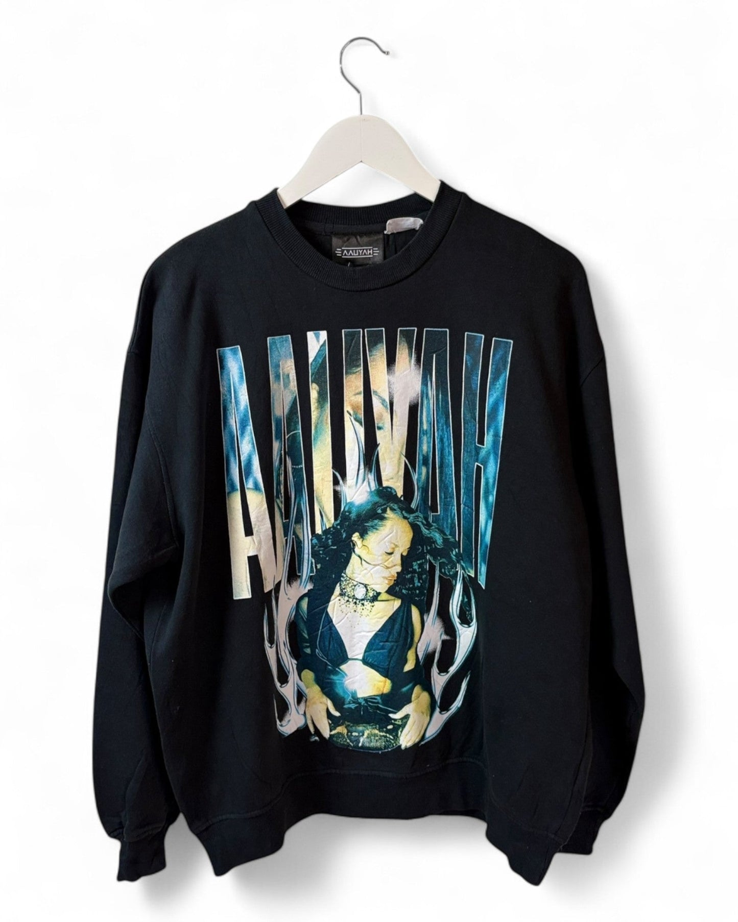 DESCRIPTION

Official Aaliyah sweater. This black crewneck features an iconic photo print of Aaliyah.